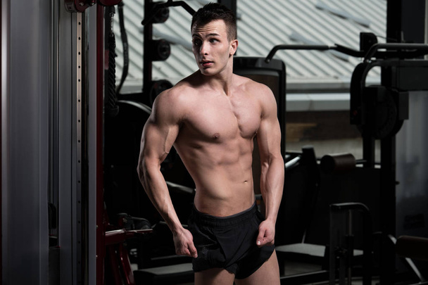Portrait Of A Young Physically Fit Man Showing His Well Trained Body - Muscular Athletic Bodybuilder Fitness Model Posing After Exercises - Foto, afbeelding