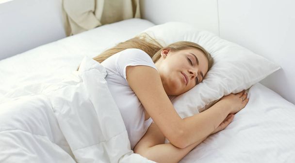 schönes Mädchen schläft im Schlafzimmer, auf dem Bett liegend - Foto, Bild