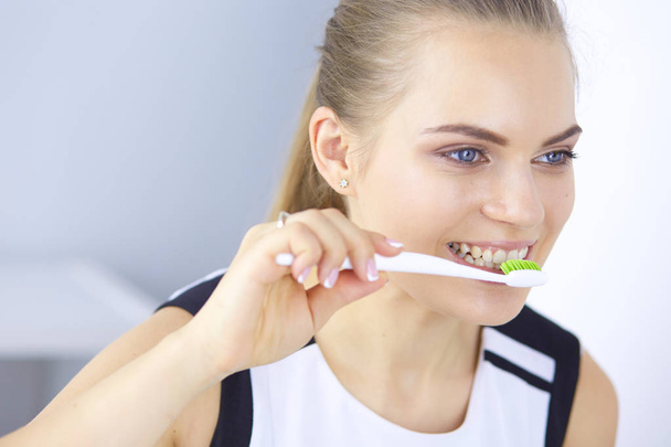 Souriante jeune femme avec des dents saines se brossant les dents
 - Photo, image