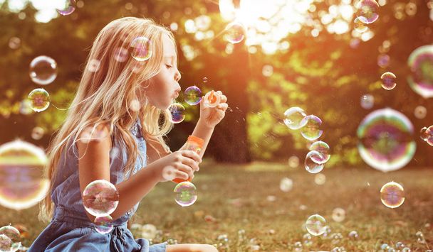 Portrait d'un enfant joyeux soufflant des bulles de savon
 - Photo, image