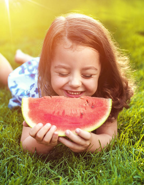 Closeup πορτρέτο του χαμογελαστού παιδιού κρατώντας φέτα καρπούζι στον κήπο - Φωτογραφία, εικόνα