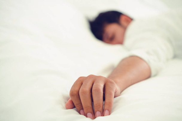 Giovane uomo dormire in biancheria bianca letto in camera da letto
. - Foto, immagini