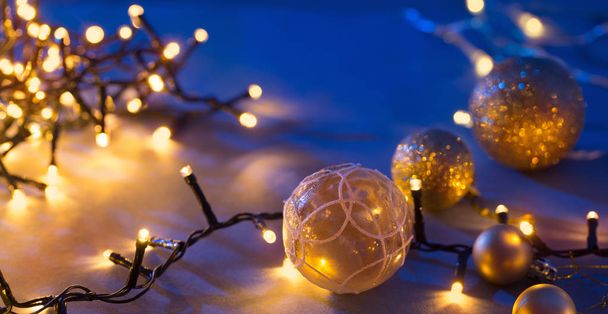 Christmas golden balls and lights on blue background - Valokuva, kuva