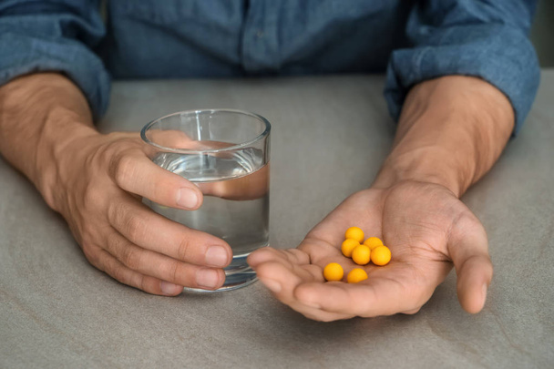 Ember tartja a tabletták és pohár vizet asztalon, Vértes - Fotó, kép
