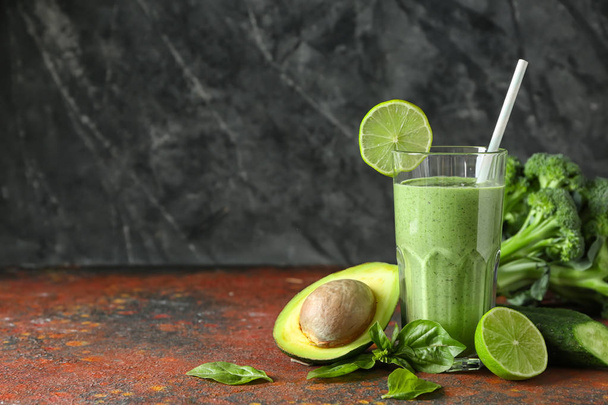 Glass of tasty green smoothie and ingredients on color table - Zdjęcie, obraz