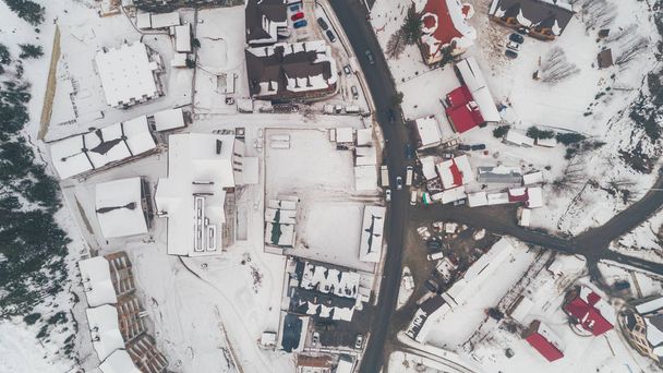Luftaufnahme von Gebäuden im Schnee. Bukovel. Winter. Karpaten. Auf der Straße stehen Autos. Ukraine. - Foto, Bild