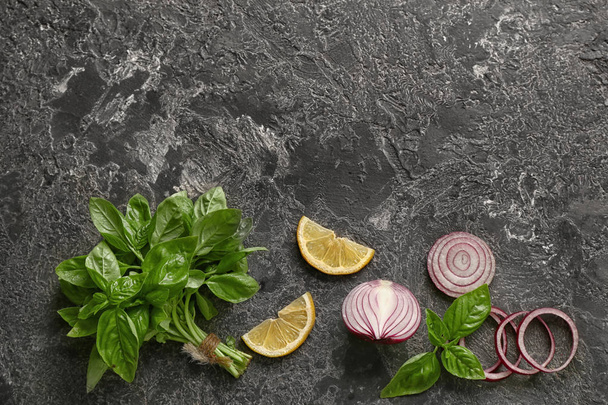 Fresh aromatic basil with onion and lemon slices on grey background - Фото, изображение