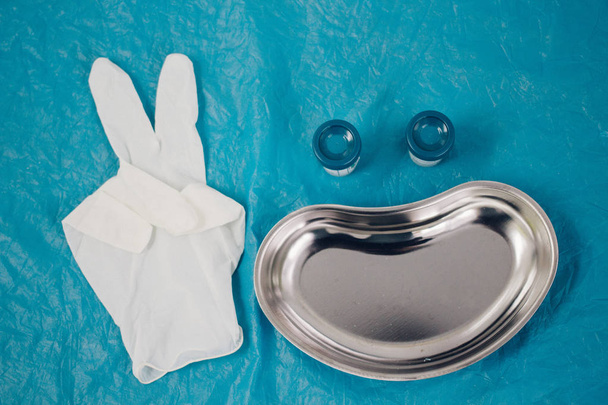 medical tray, disposable gloves showing the peace sign, jars for taking biomaterial lined in the form of a smiling face. health, longevity, - Fotó, kép