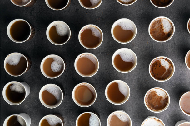 Muchas tazas de plástico con sabroso café aromático sobre fondo oscuro, plano laico
 - Foto, Imagen