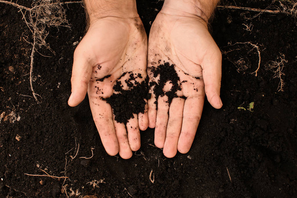 Férfi kezét fekete talaj - Fotó, kép