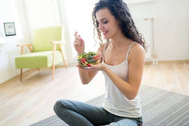 Fitness young woman eating healthy food after workout - Foto, Imagen