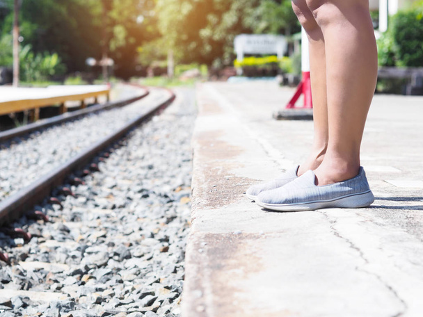 Close up asian woman tourist leg standing and waiting for the train at local platform in Thailand. Backpacker travel alone concept. - Foto, Imagem
