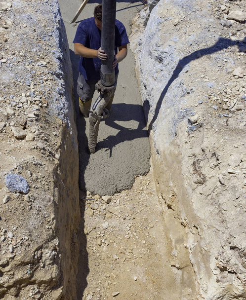 будівельник будівельник заливає цемент або бетон насосною трубкою
 - Фото, зображення