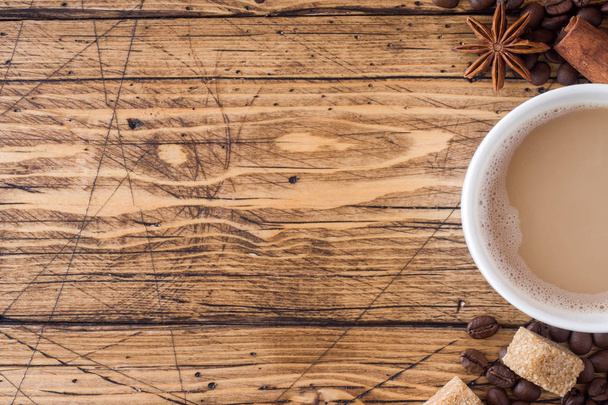 Cup of coffee, brown sugar and cinnamon with anise on a wooden background. Copy space. - Foto, afbeelding