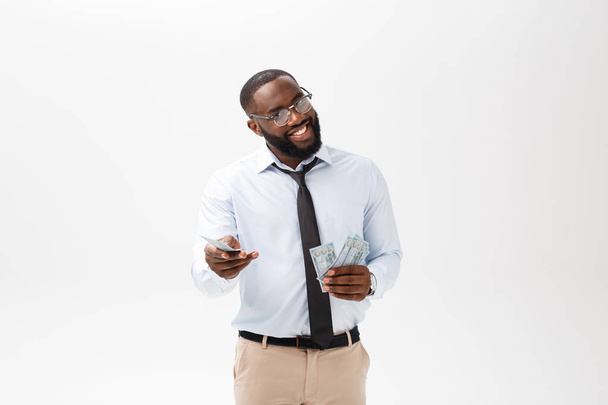 young cheerful black businessman holding and pointing at money isolated on white. - Фото, зображення
