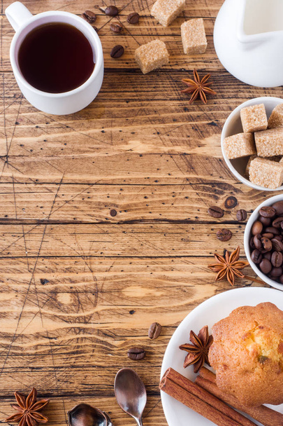 Breakfast coffee with milk, pastries, brown sugar and cinnamon with anise on wooden background - Fotó, kép