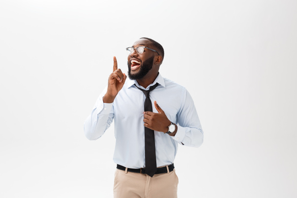 junger afrikanisch-amerikanischer beschaulicher Geschäftsmann steht mit der Hand vor dem Mund im Büro, holt sich Geschäftsideen - Foto, Bild
