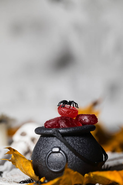 Trick or treat! Kaarsen in de ketel voor Halloween. Schedels in de achtergrond - Foto, afbeelding