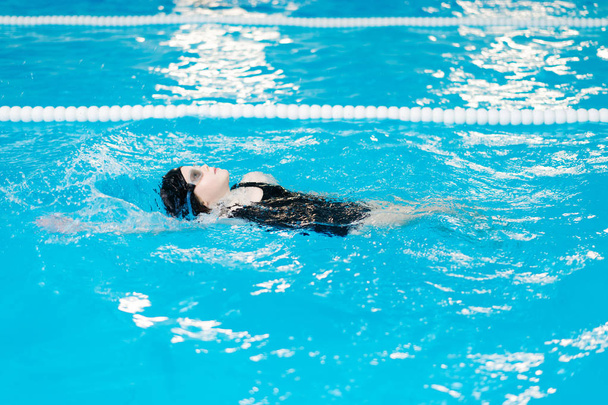 clases de natación para niños en la piscina - hermosa chica de piel clara nada en el agua
 - Foto, Imagen