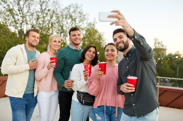 friends with drinks taking selfie at rooftop party - Foto, Imagem