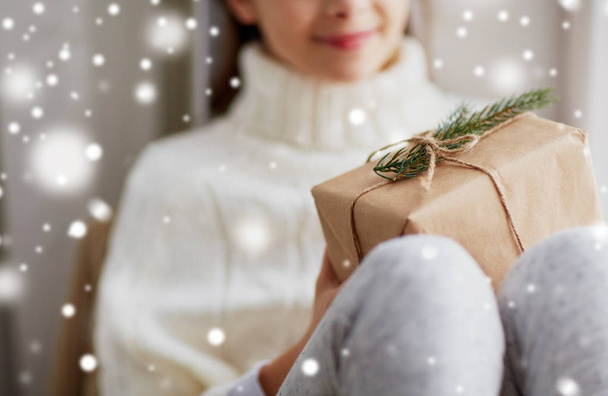girl with christmas gift sitting on sill at home - Foto, Imagen