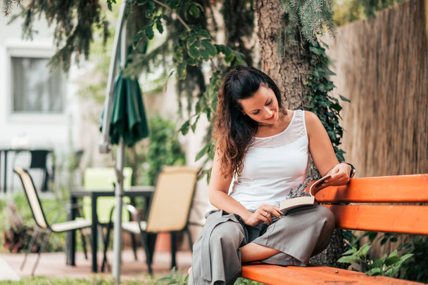 Portrait of a lady reading a book outdoors. - Fotó, kép