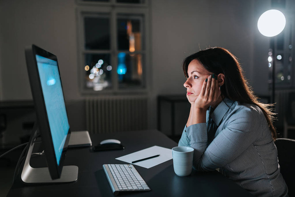 Exhausted entrepreneur looking at computer screen. - Фото, изображение