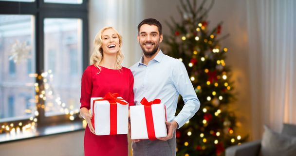 happy couple with christmas gifts at home - 写真・画像
