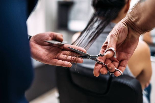 Hairdresser's hands cutting hair. Close-up. - Фото, зображення