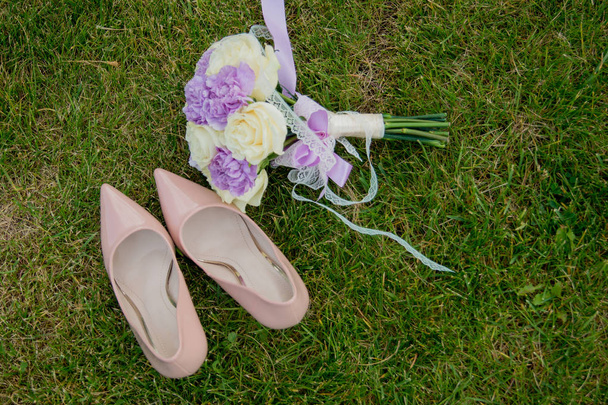 Shoes and wedding bouquet on the grass - 写真・画像