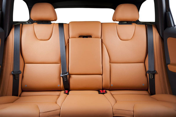 Задние пассажирские сиденья в современном роскошном автомобиле, вид спереди, кожа из красного песка
 - Фото, изображение