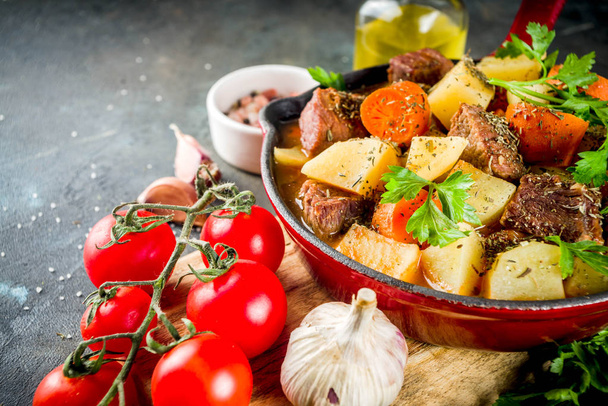 Guisado de carne caseira, goulash húngaro com batatas, cenouras e ervas no fundo escuro espaço de cópia vista superior
 - Foto, Imagem