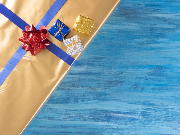 Ansicht der goldenen Weihnachtsgeschenkboxen auf altem, blauem Holzhintergrund - Foto, Bild
