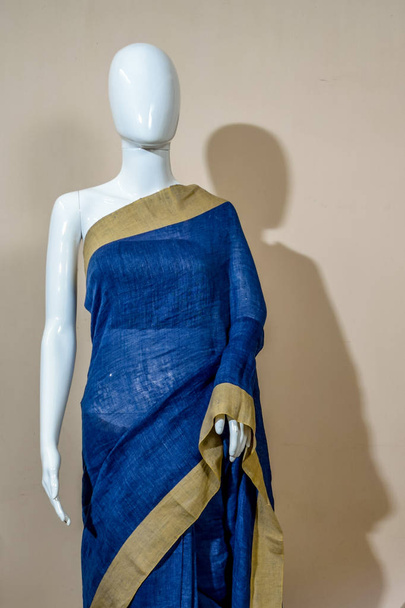 Μια παραδοσιακή ινδική saree μετάξι εκτίθενται προς πώληση. Επιλεκτική εστίαση στο πρόσωπό του μοντέλου - Φωτογραφία, εικόνα