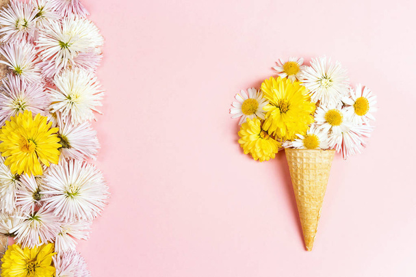Waffle cone with flowers on pink background. Flat lay, copy space, top view. - Φωτογραφία, εικόνα