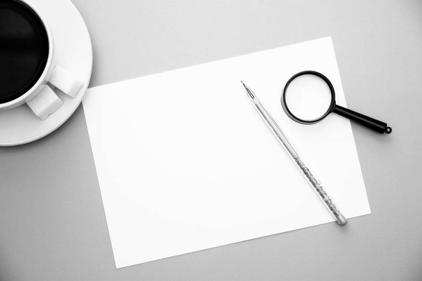 černo-bílý obrázek zobrazit Lupa dokument white paper Pen a šálek kávy na žlutém pozadí s kopie prostor nahoře. - Fotografie, Obrázek