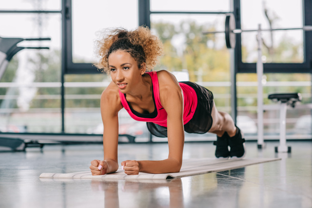 mutlu Afro-Amerikan sporcumuz tahta spor salonunda fitness mat yapıyor - Fotoğraf, Görsel
