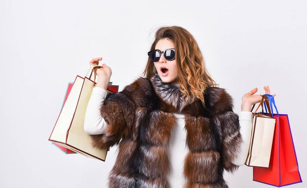 Lady hold shopping bags. Discount and sale. Buy with discount on black friday. Shopping with promo code. Woman shopping luxury boutique. Girl wear sunglasses and fur coat shopping white background - Fotografie, Obrázek