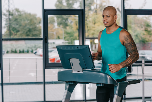 young african american sportsman running on treadmill at gym - Foto, immagini
