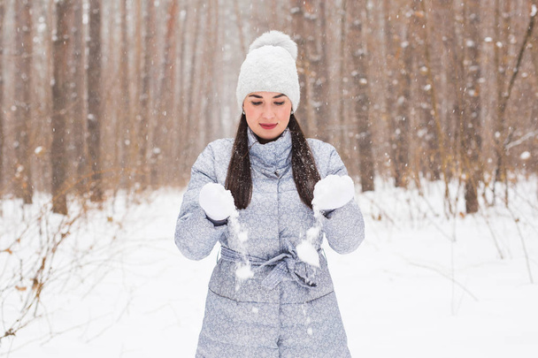 Concept hiver, vacances et personnes - une jeune femme joyeuse est heureuse de se promener dans la forêt d'hiver avec de la neige
 - Photo, image
