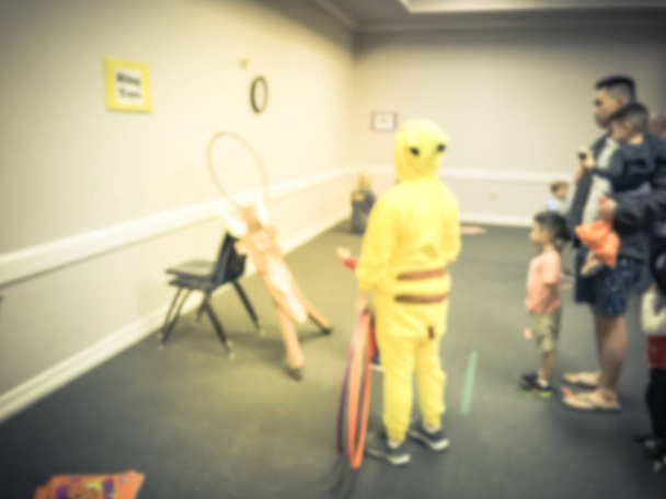 verschwommen abstrakten Kinder und Eltern genießen Indoor-Halloween-Party in der Schule in Texas, Amerika. defokussierte Kinder mit Kostümen bei Herbstspaßspielen, Shape Links - Foto, Bild