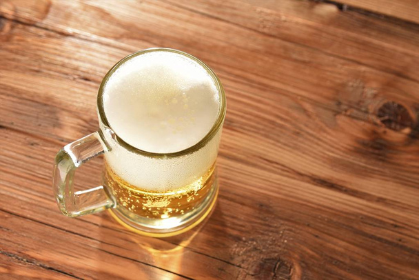 bira cam ahşap masa üzerinde - Fotoğraf, Görsel