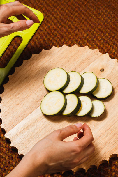 Freshly chopped green zucchini on wooden cutting board - Φωτογραφία, εικόνα