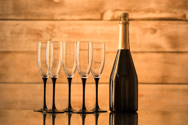 a bottle of champagne and empty glasses - Фото, изображение