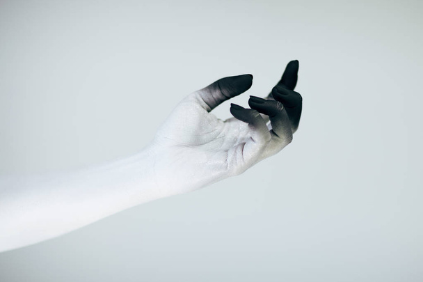Creepy Halloween monster hand with white and black make up in front of white background - Photo, image