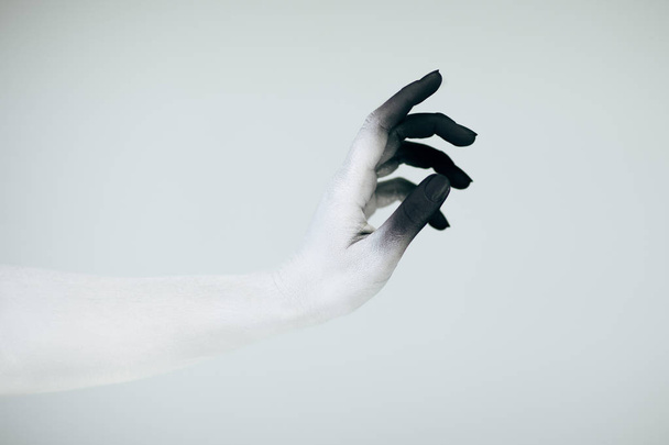 Creepy Halloween monster hand with white and black make up in front of white background - Foto, immagini