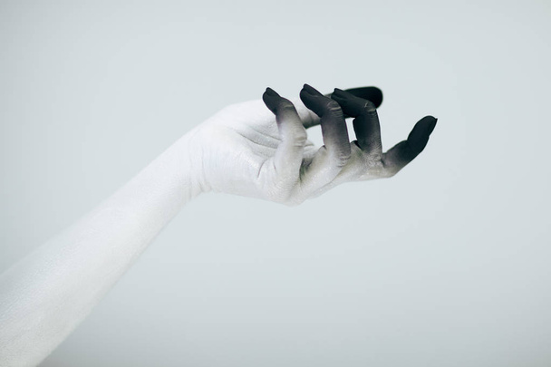 Creepy Halloween monster hand with white and black make up in front of white background - Photo, image