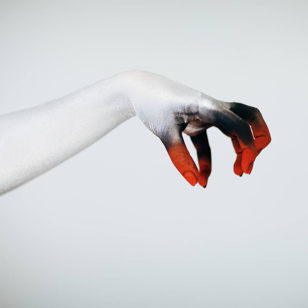 Creepy Halloween monster hand with white, red and black make up in front of white background - Foto, Imagen