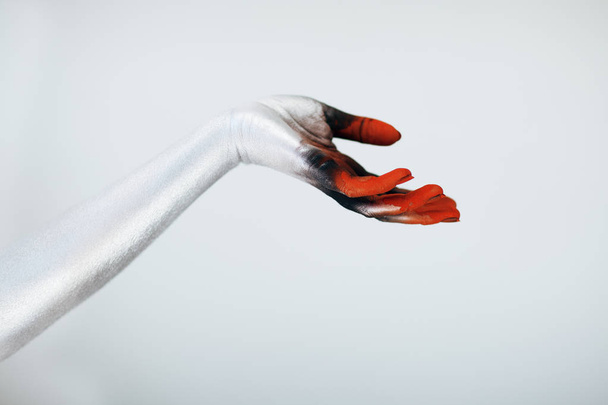Creepy Halloween monster hand with white, red and black make up in front of white background - Fotoğraf, Görsel