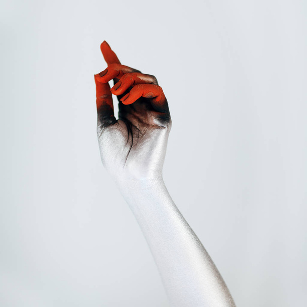 Creepy Halloween monster hand with white, red and black make up in front of white background - Foto, afbeelding